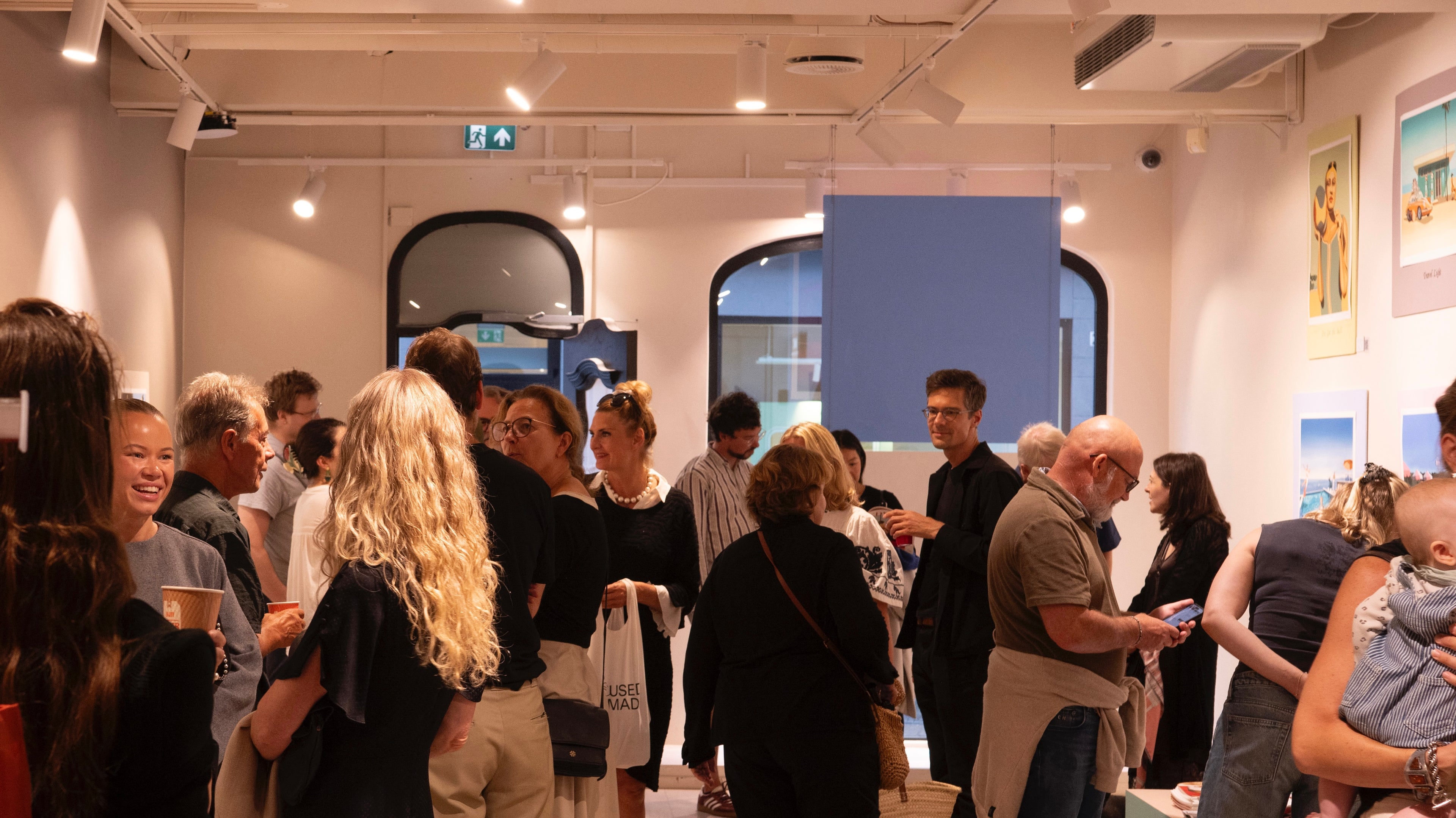 Photo of a gallery filled with people from the opening night of Edvarda Store